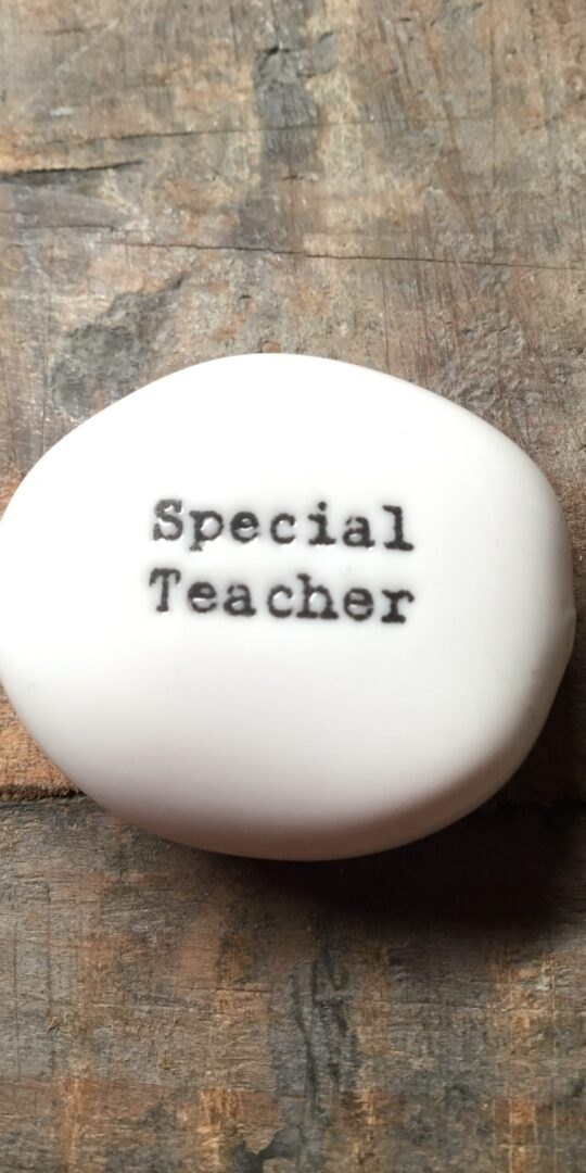 East Of India Small White Porcelain Pebble with Black Type Engraved. Saying: Special Teacher