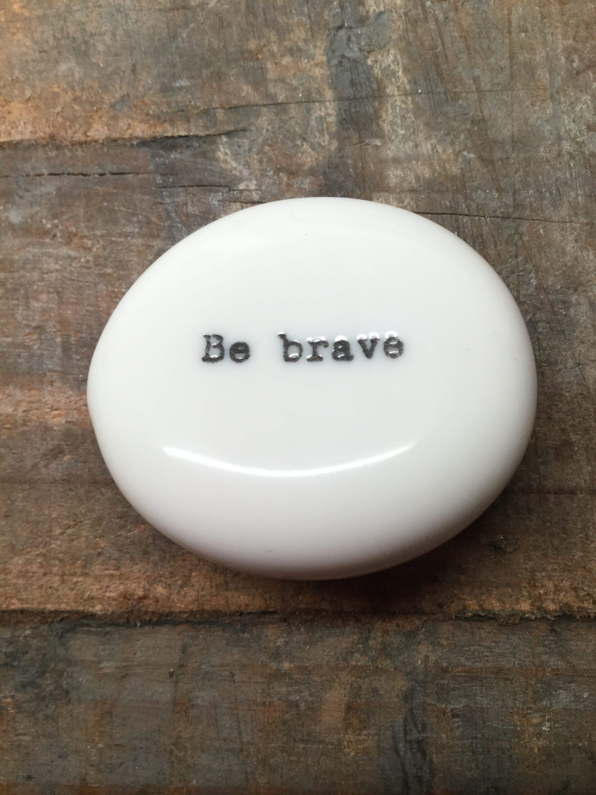 East Of India Small White Porcelain Pebble with Black Type Engraved. Saying: Be Brave