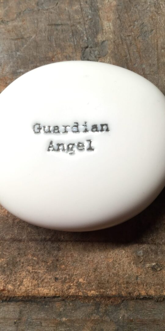 East Of India Small White Porcelain Pebble with Black Type Engraved. Saying: Guardian Angel