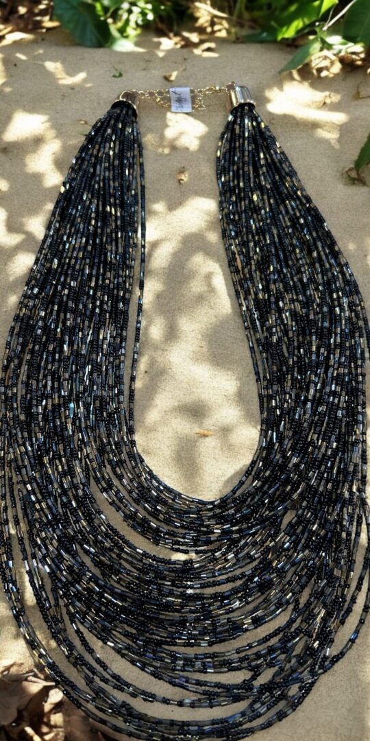 Cascade of tiny black, charcoal and silver beads in multiple layers.