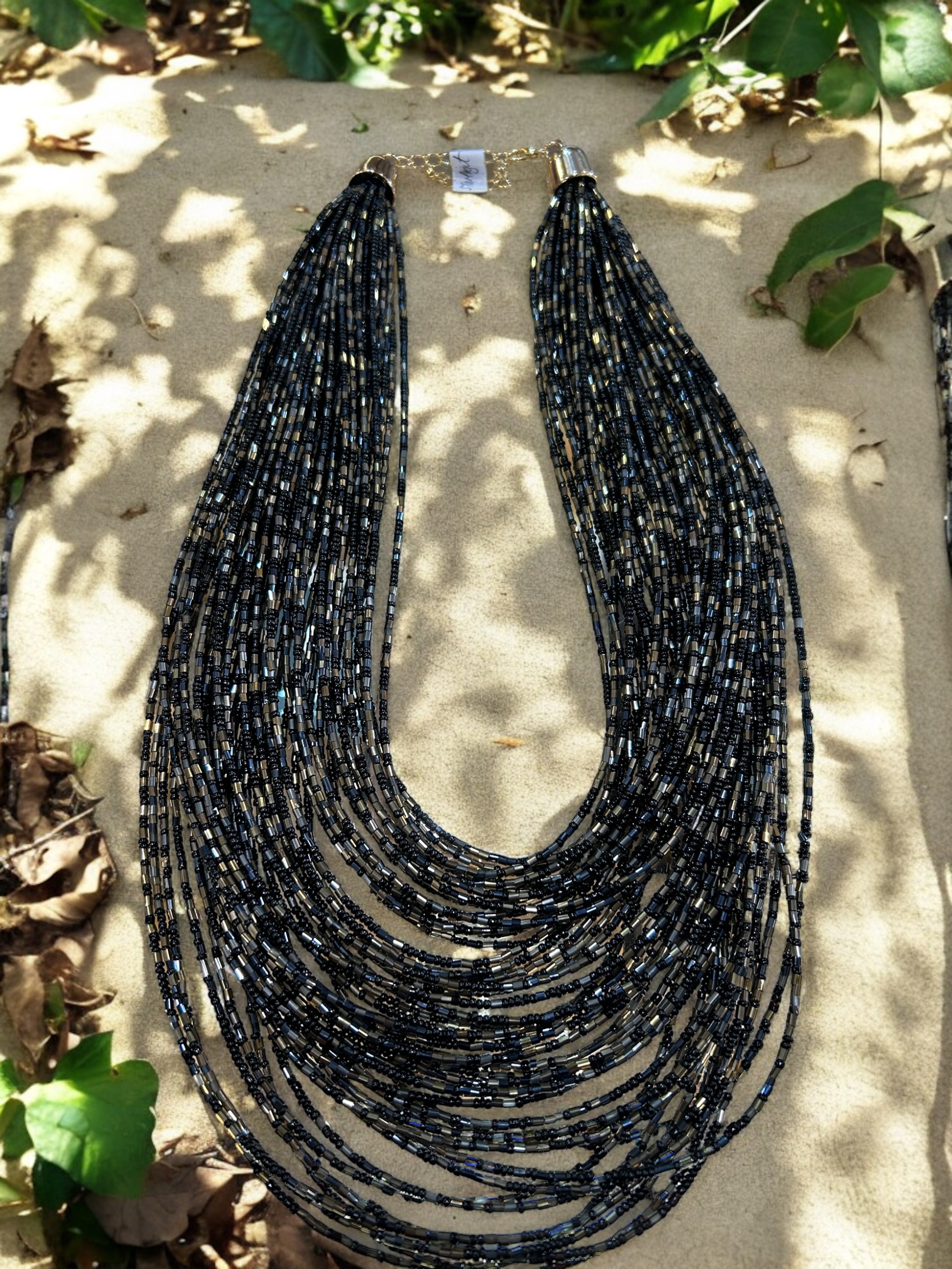 Cascade of tiny black, charcoal and silver beads in multiple layers.