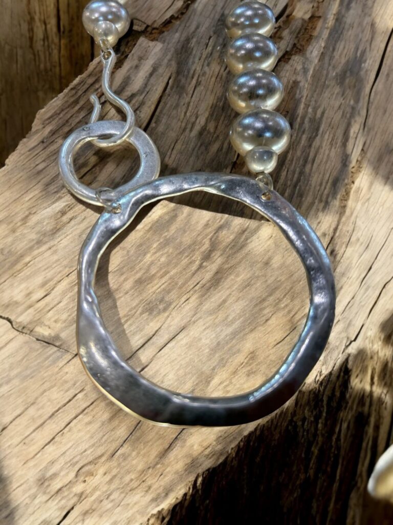 Large pearl style beads necklace closing into two adjoining rings.