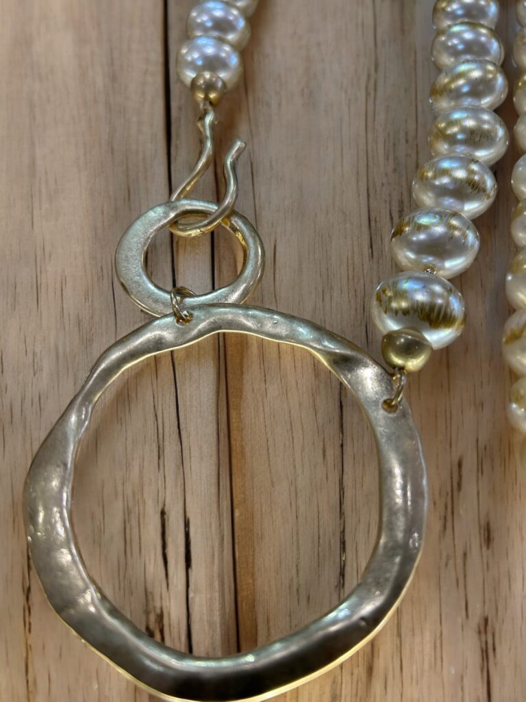Large pearl style beads necklace closing into two adjoining golden rings.