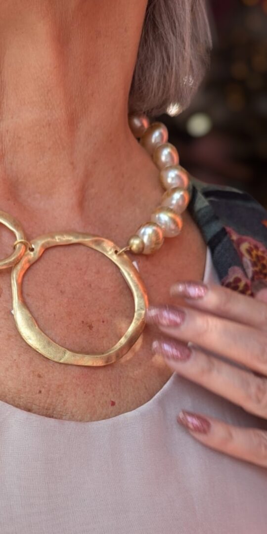 Large pearl style beads necklace closing into two adjoining golden rings.