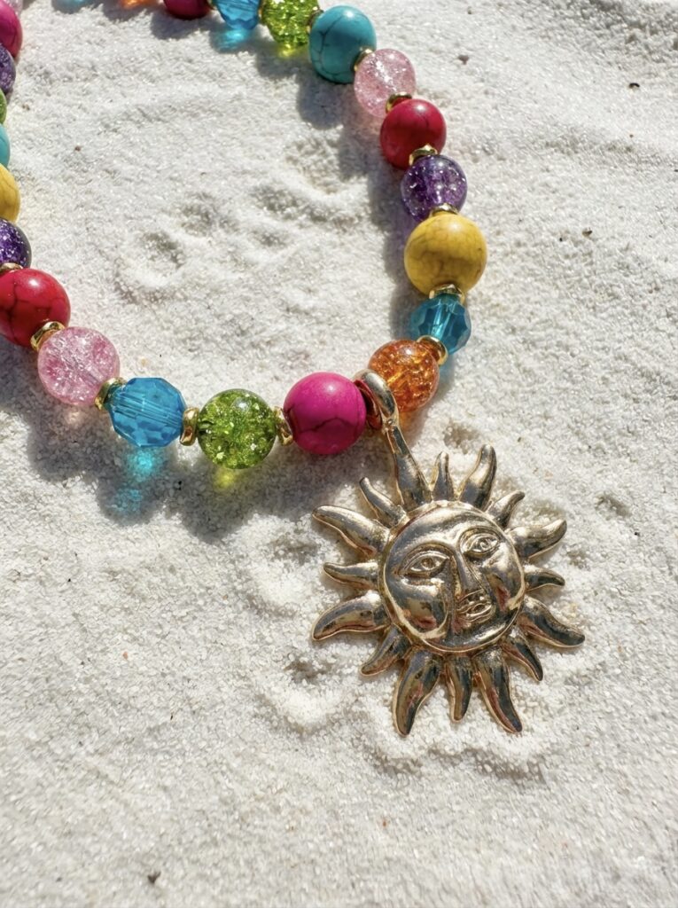 Sundown necklace with mixed colour beads in glass and ceramic and a large sunshine charm