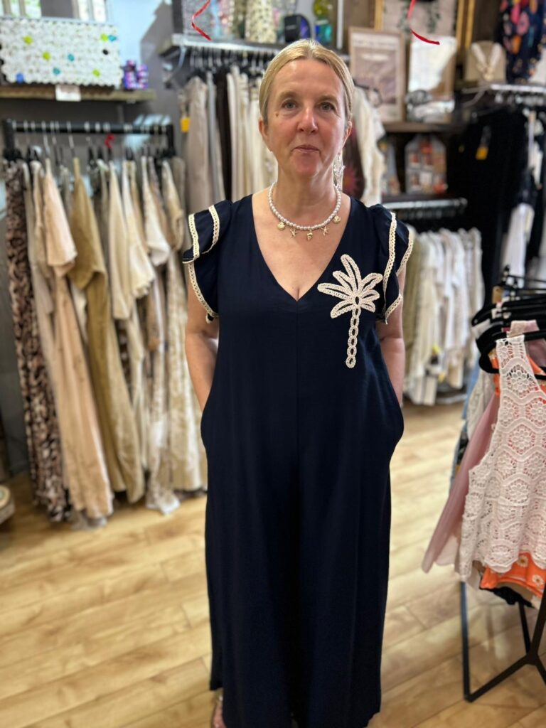 Palm romper suit. Palm embroidery, sleeve detail, tie at the back. Navy.